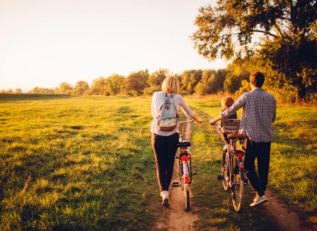 Young family with one child is cycling together outdoors